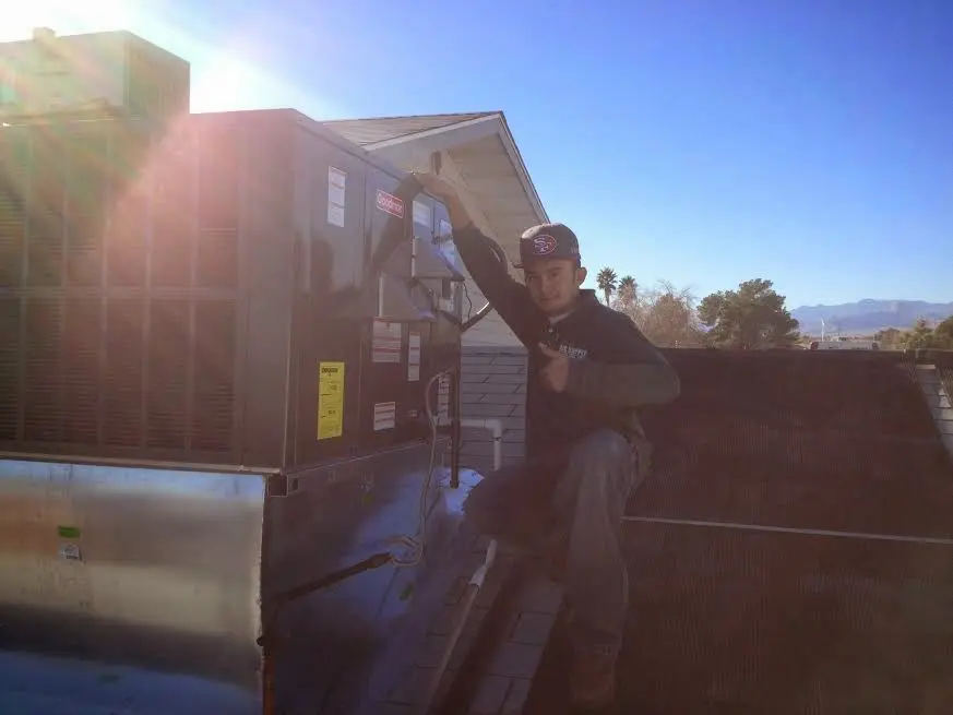 HVAC technician performing AC Tune-Up on a rooftop unit in Kent